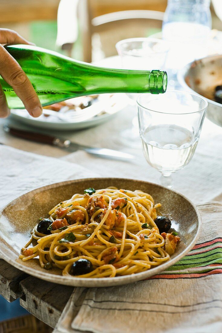 Spaghetti alla puttanesca with olives (pasta dish with olives and capers)
