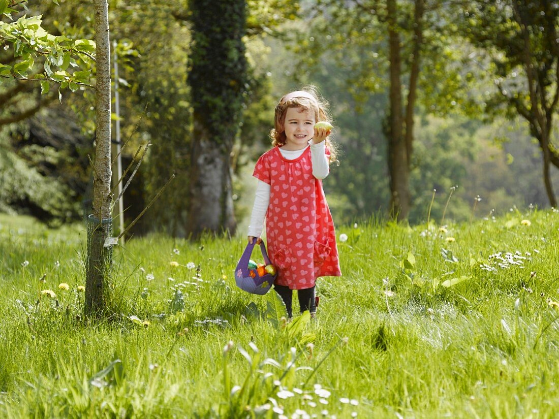 A girl looking for Easter eggs in a meadow