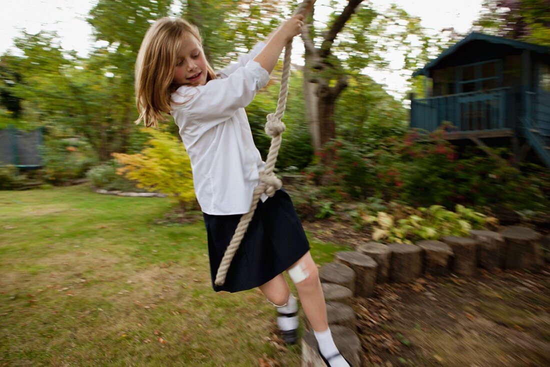 Girl playing with a rope in garden
