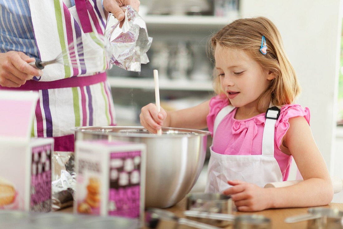 Mother and daughter with flour on nose baking in kitchen