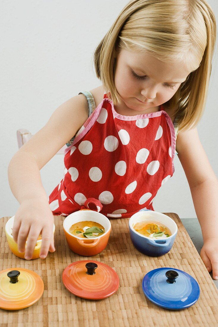 A little girl making baked eggs