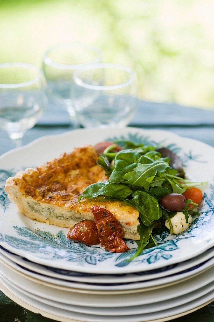 A slice of vegetable quiche with salad
