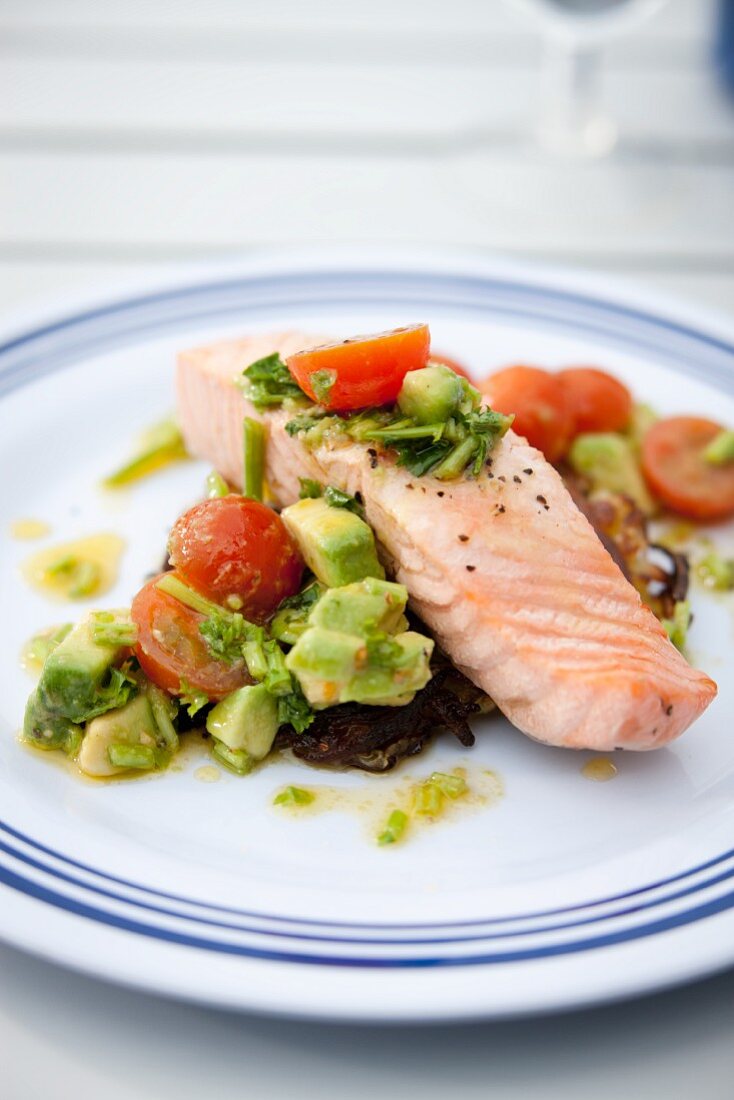 Poached salmon fillet with tomato and avocado salad on a hash brown