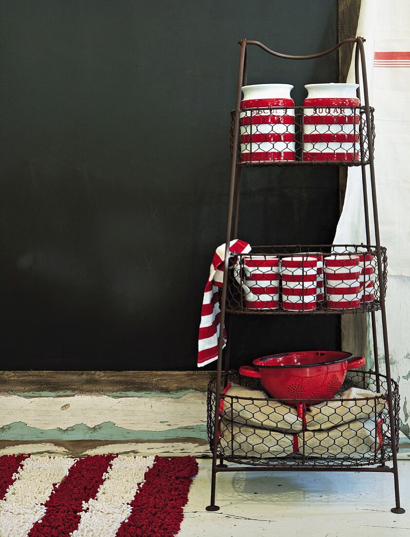 Red and white striped ceramic pots on metal shelving with wire baskets