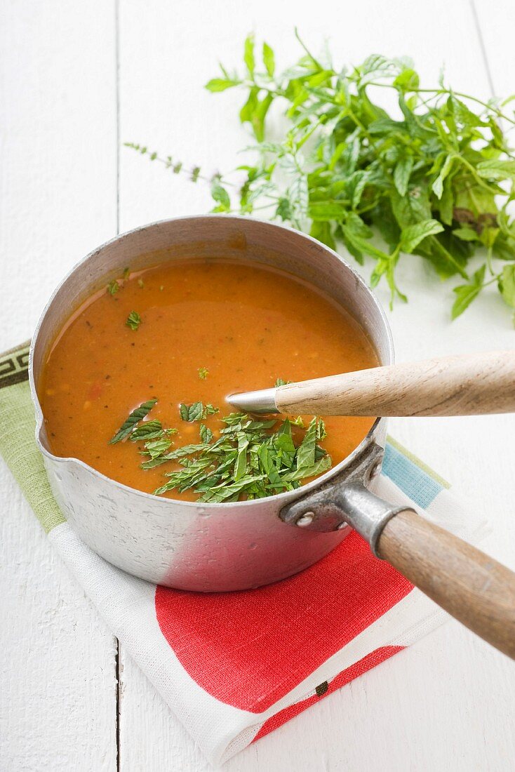 Tomato soup with mint in a saucepan