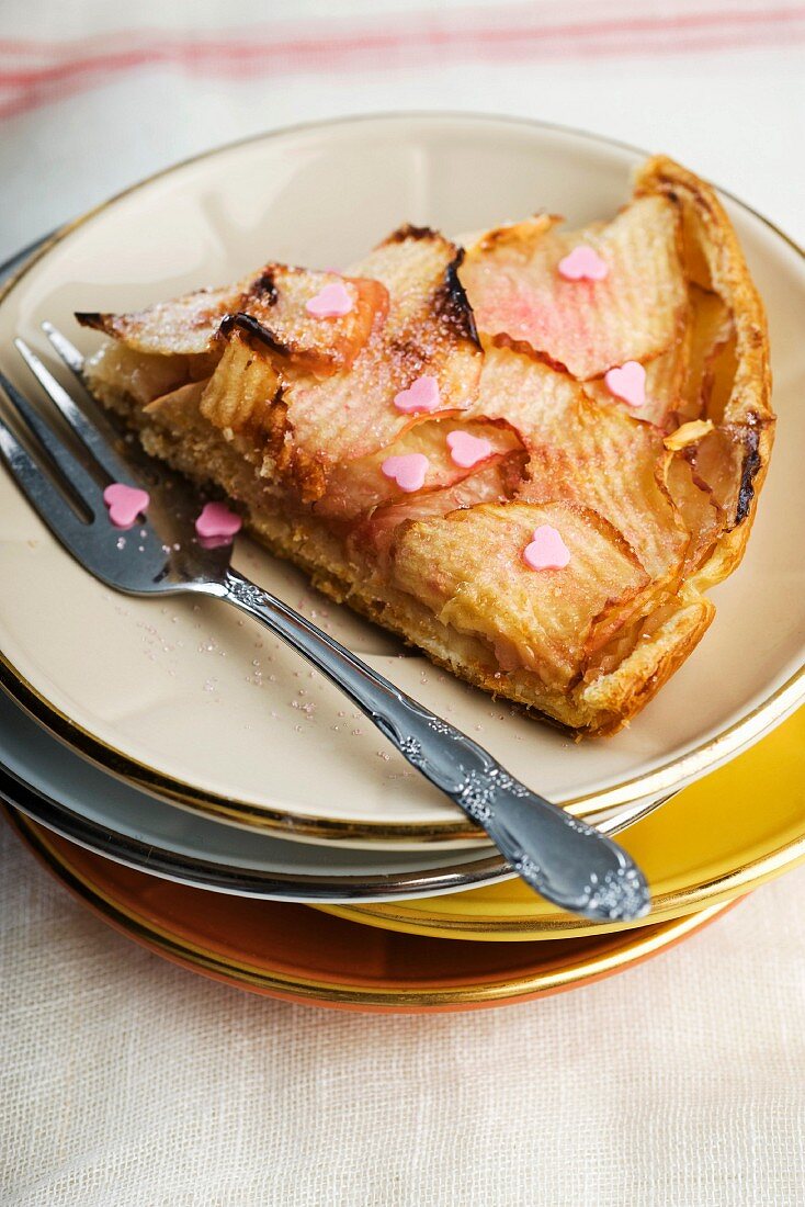 A slice of nectarine and apple tart decorated with sugar hearts