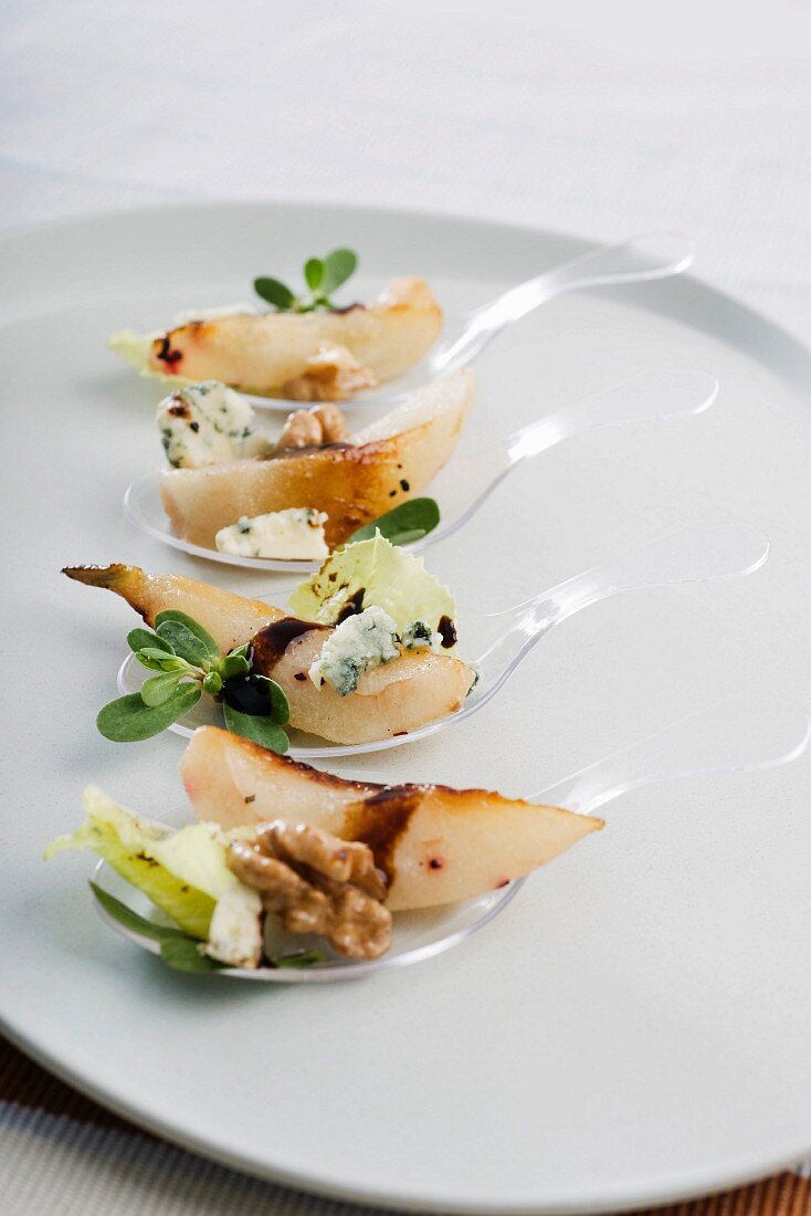 Spoon canapés with sautéed pears and blue cheese