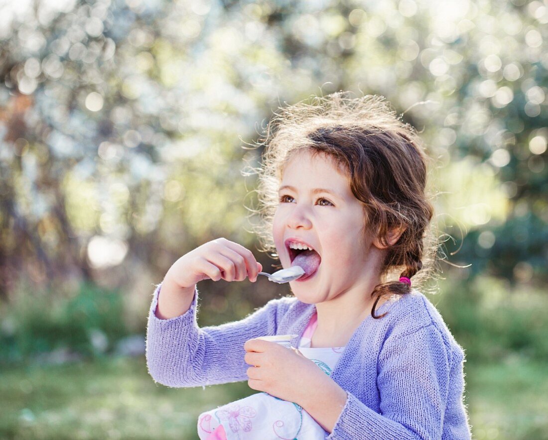 A little girl eating with relish