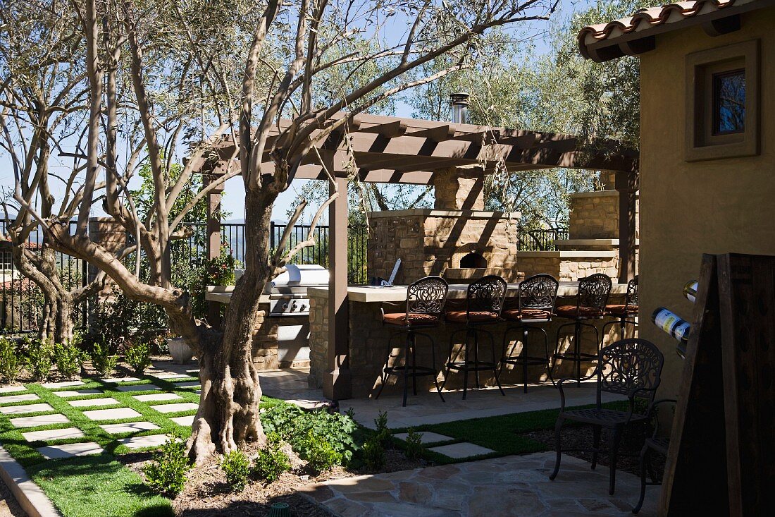 Tuscan backyard patio with grill and bar