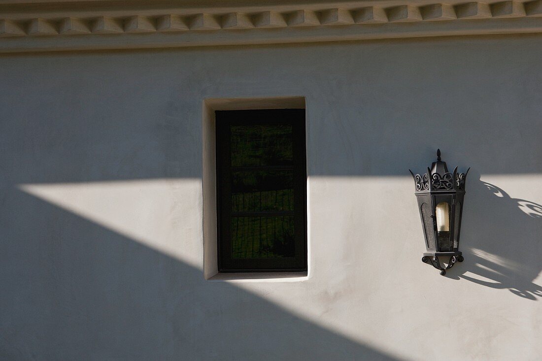 Italianate lantern style sconce on exterior wall near window