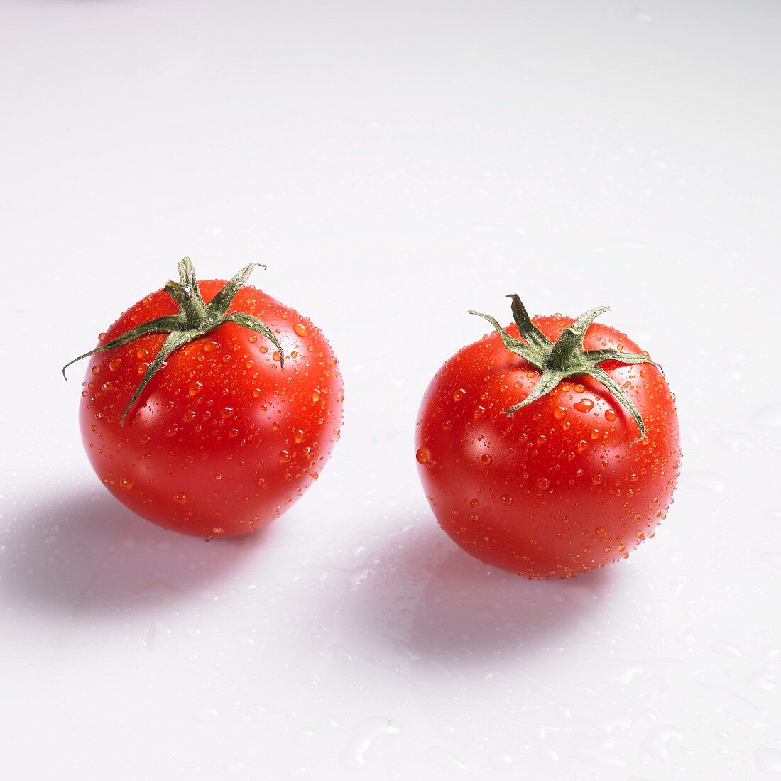 Two tomatoes with drops of water