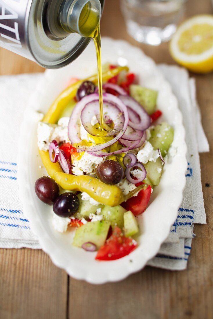 Griechischen Salat mit Olivenöl begiessen