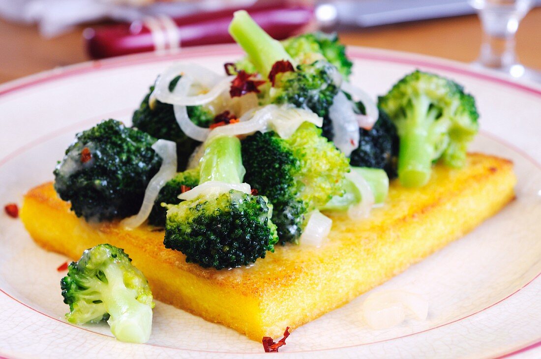 A slice of fried polenta topped with broccoli and chilli