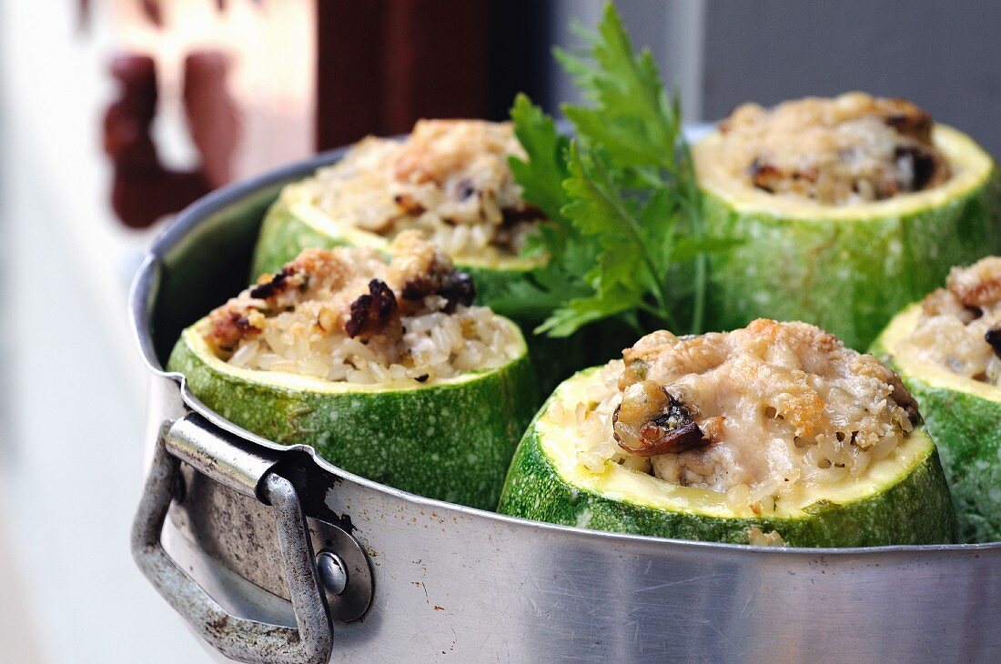 Round courgettes filled with rice in a baking tin