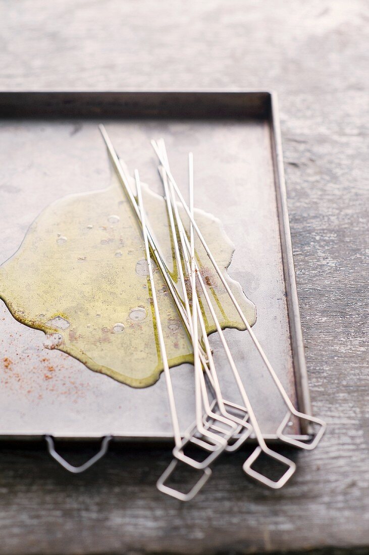 Skewers and oil on a baking tray
