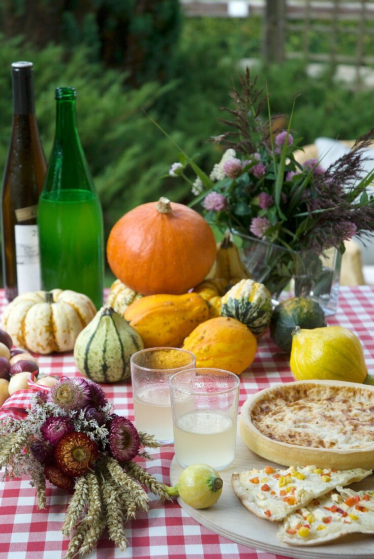 An autumnal tables laid with pumpkins, Federweisser wine and quiche