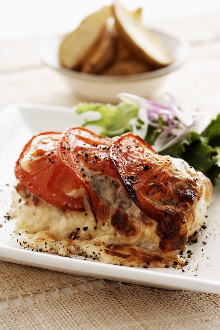 Fish steak gratinated with tomatoes and mozzarella