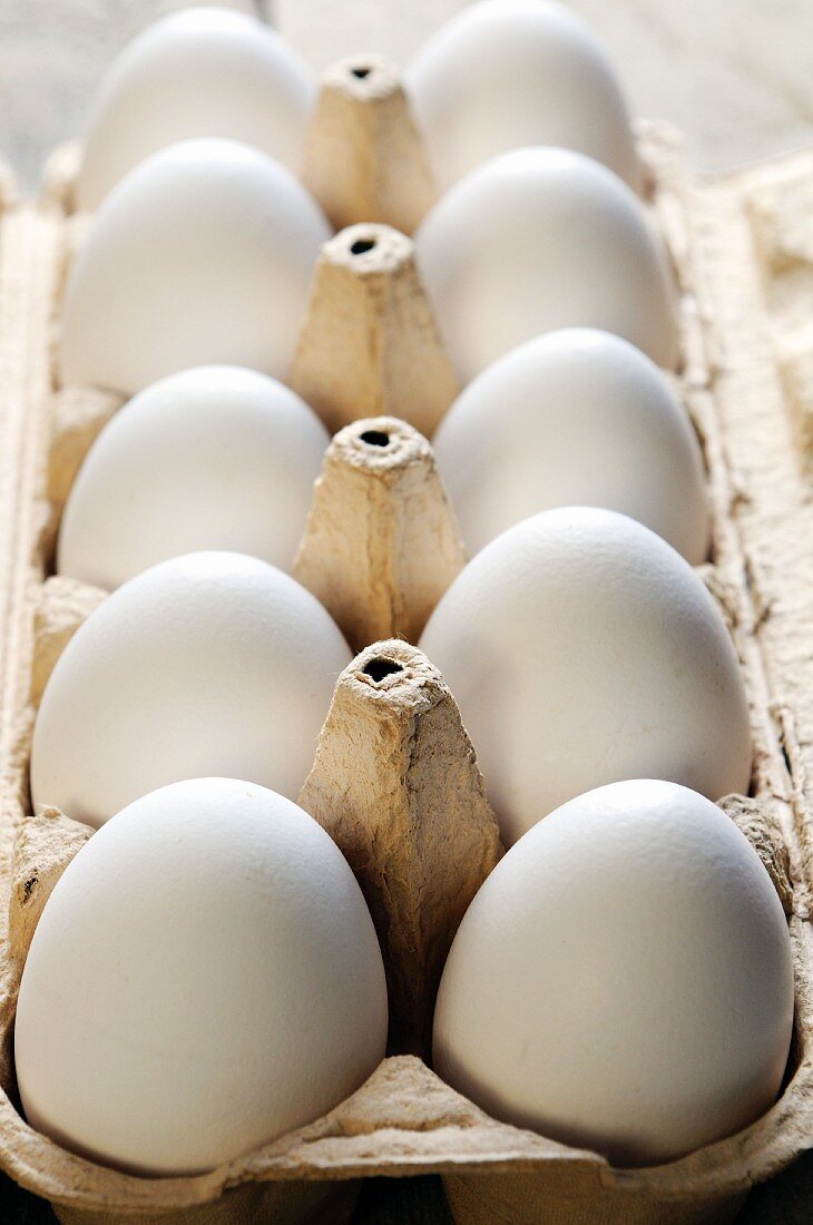 Ten white eggs in an egg box