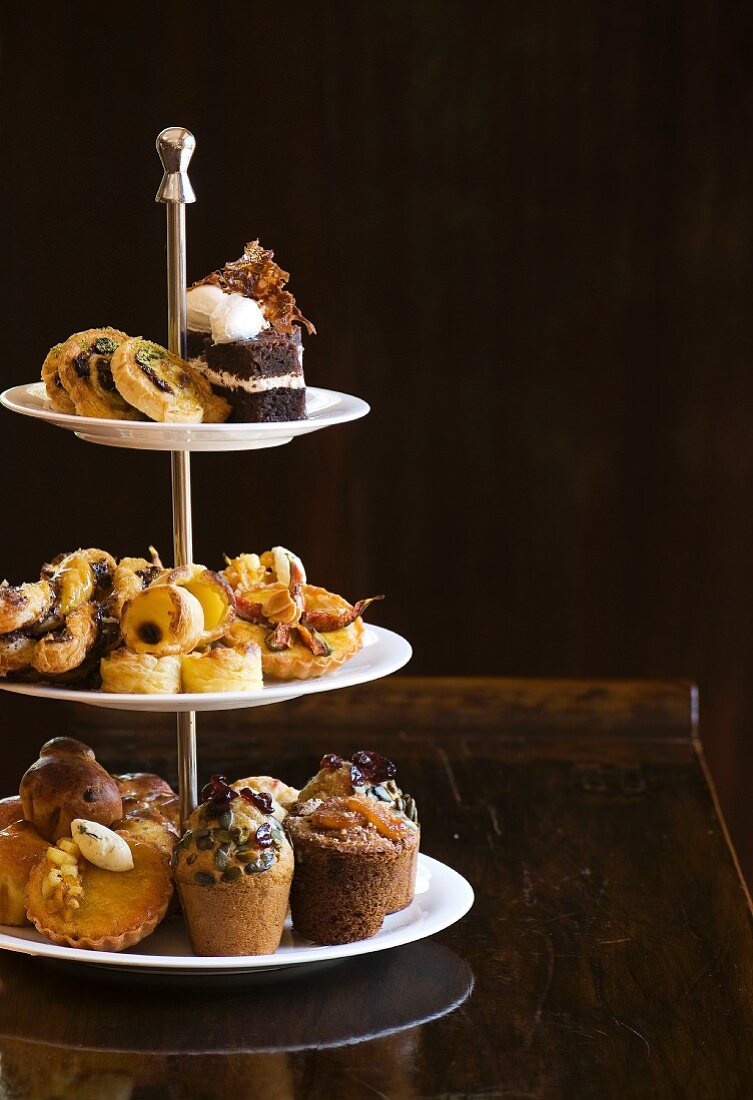 Various types of breakfast pastries and muffins on a cake stand