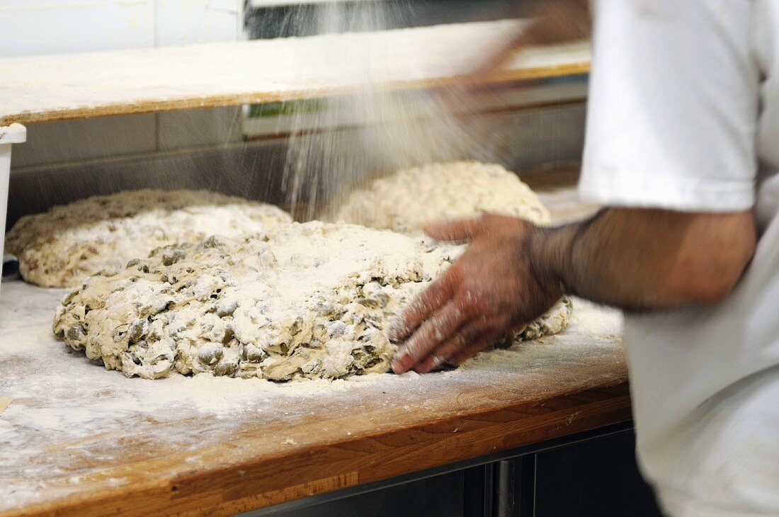 Ungebackene Olivenbrote werden mit Mehl bestreut