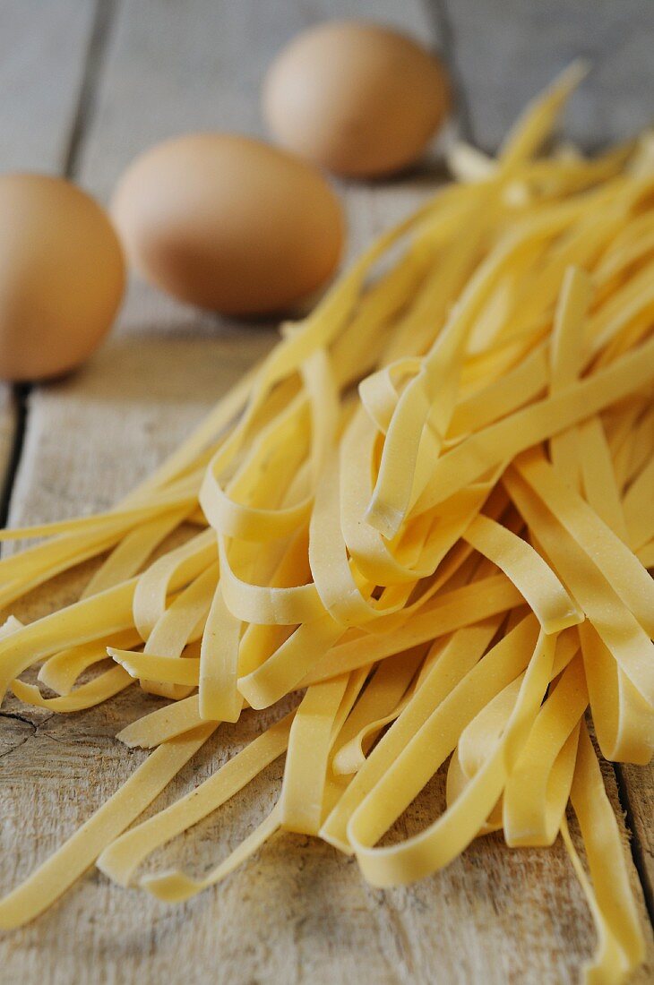 Tagliatelle and eggs on a wooden surface