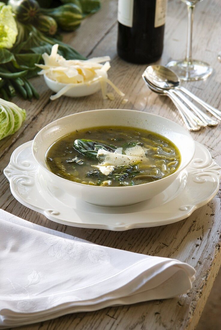 A bowl of minestrone soup made from green vegetables and pesto