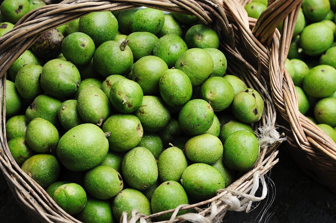 Freshly picked green walnuts in baskets