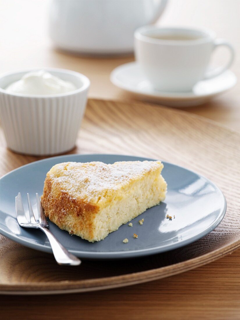 Ein Stück Mandel-Zitronen-Kuchen, Sahne und Tee