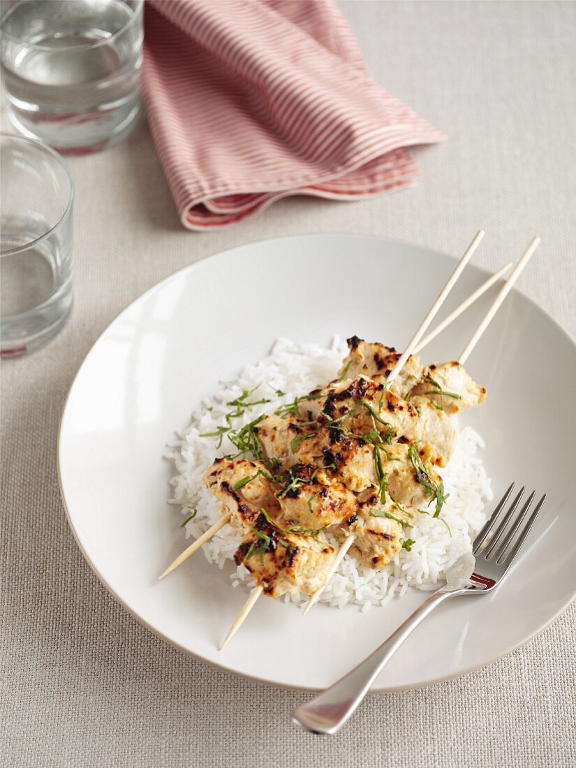 Chicken kebabs with yogurt on a bed of rice