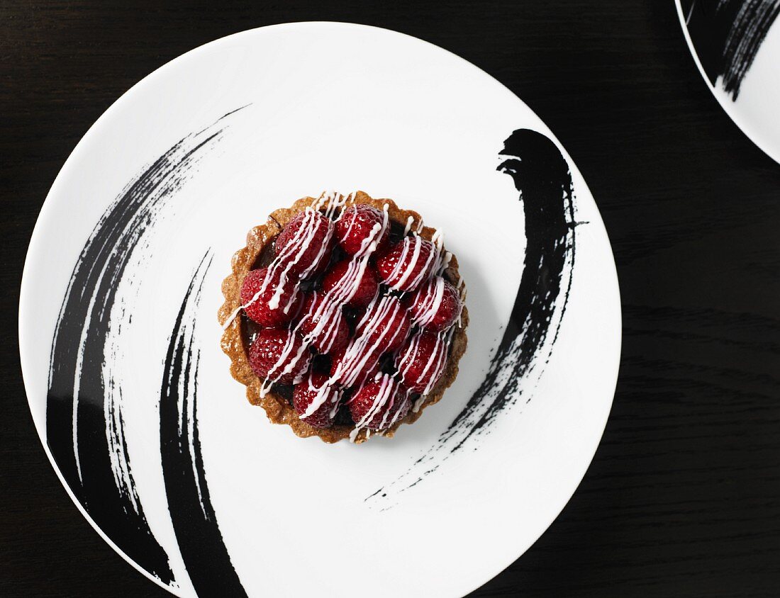 Individual Raspberry Tart on a Black and White Plate