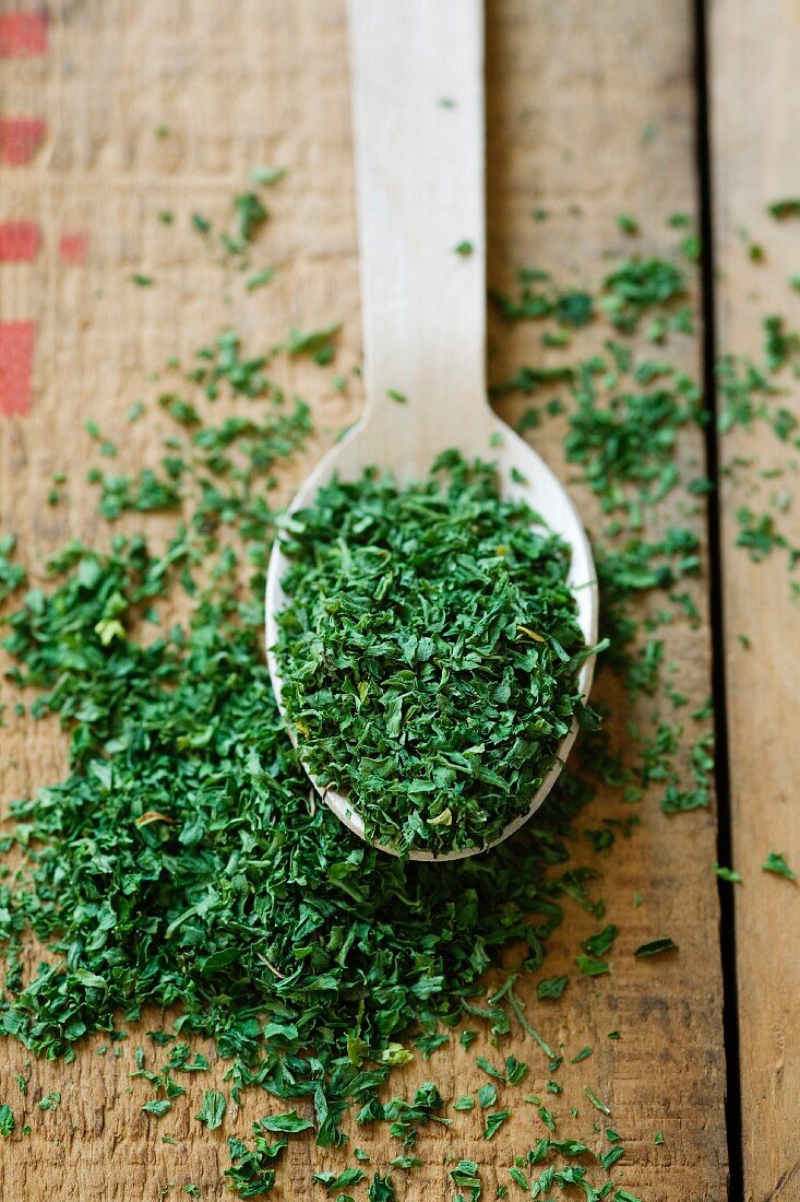 Dried parsley on a wooden spoon