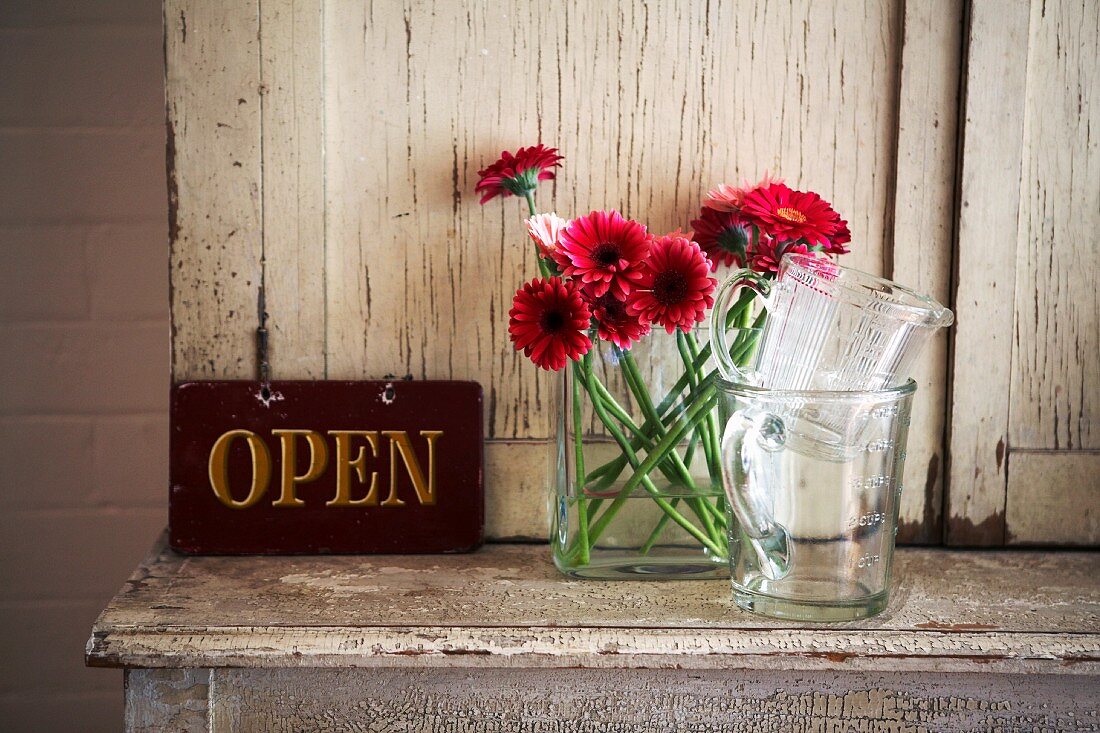 Schrank mit Blumenvase und Schild OPEN