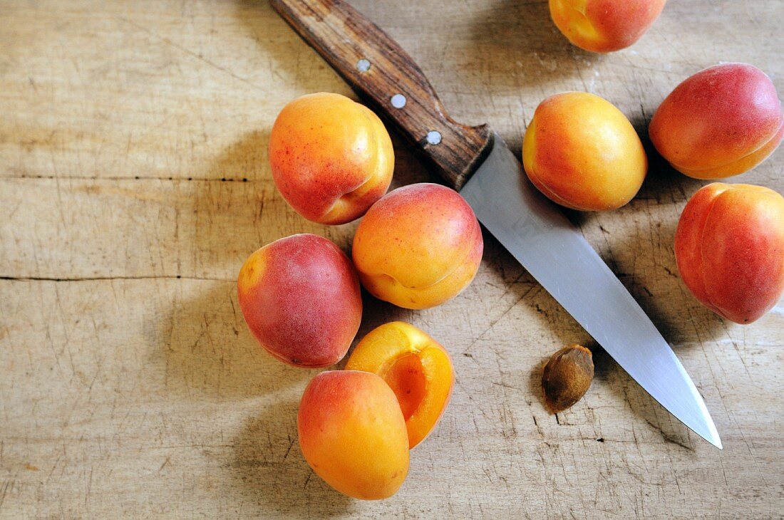 Frische Aprikosen, ganz und aufgeschnitten, Messer