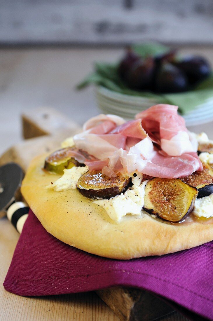 Pizza topped with mascarpone cheese, fresh figs and Parma ham