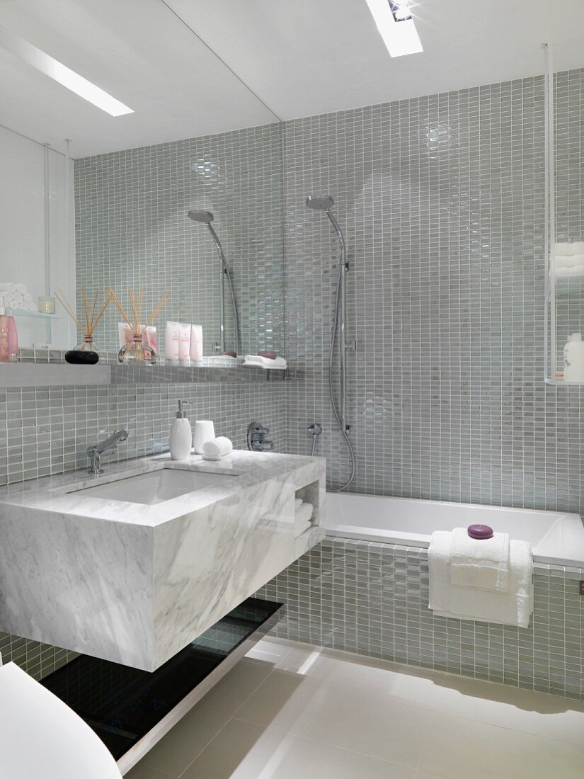 Marmor Waschtisch vor Wandspiegel im gefliesten Designer Bad
