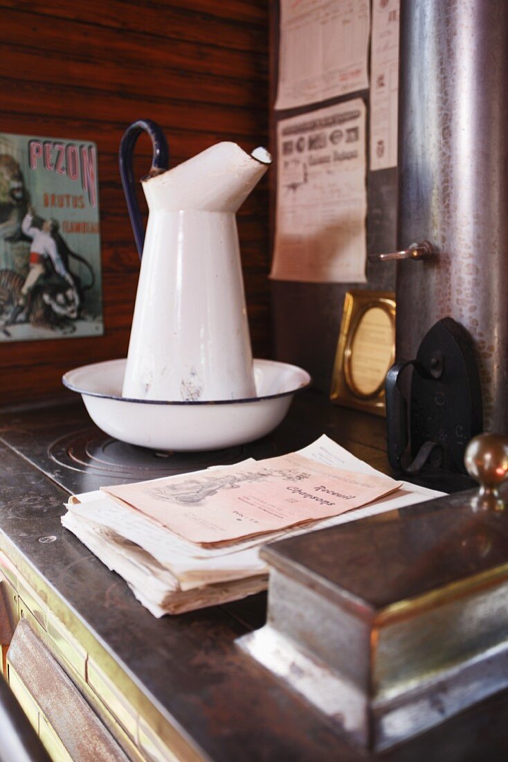 Alter Waschkrug mit Schüssel auf Vintage Küchenherd