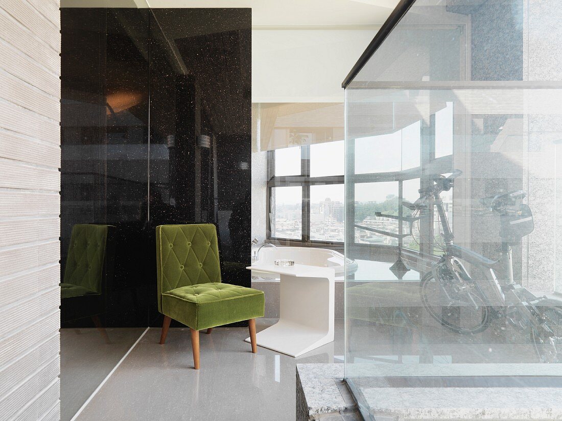 Green, fifties-style chair next to modern side table in contemporary building