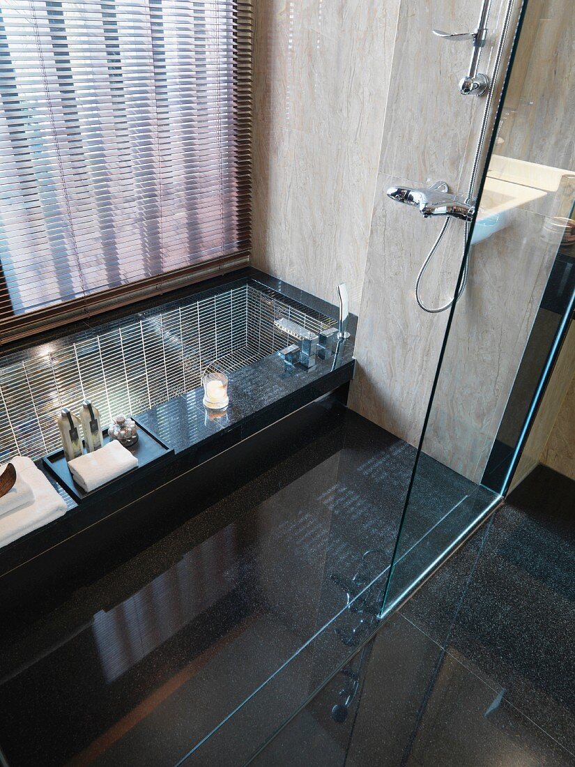 View of sunken bathtub through glass wall