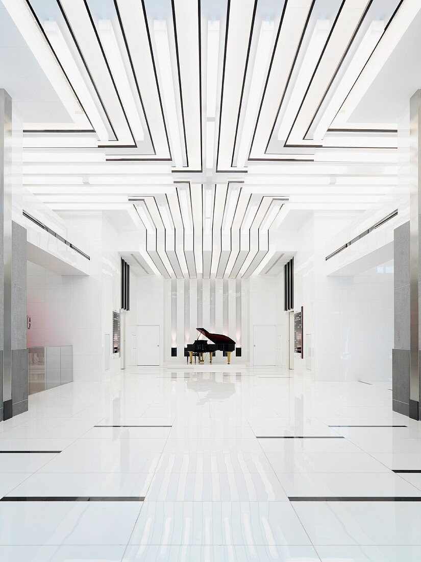 White, minimalist room with light strips on ceiling and grand piano in background