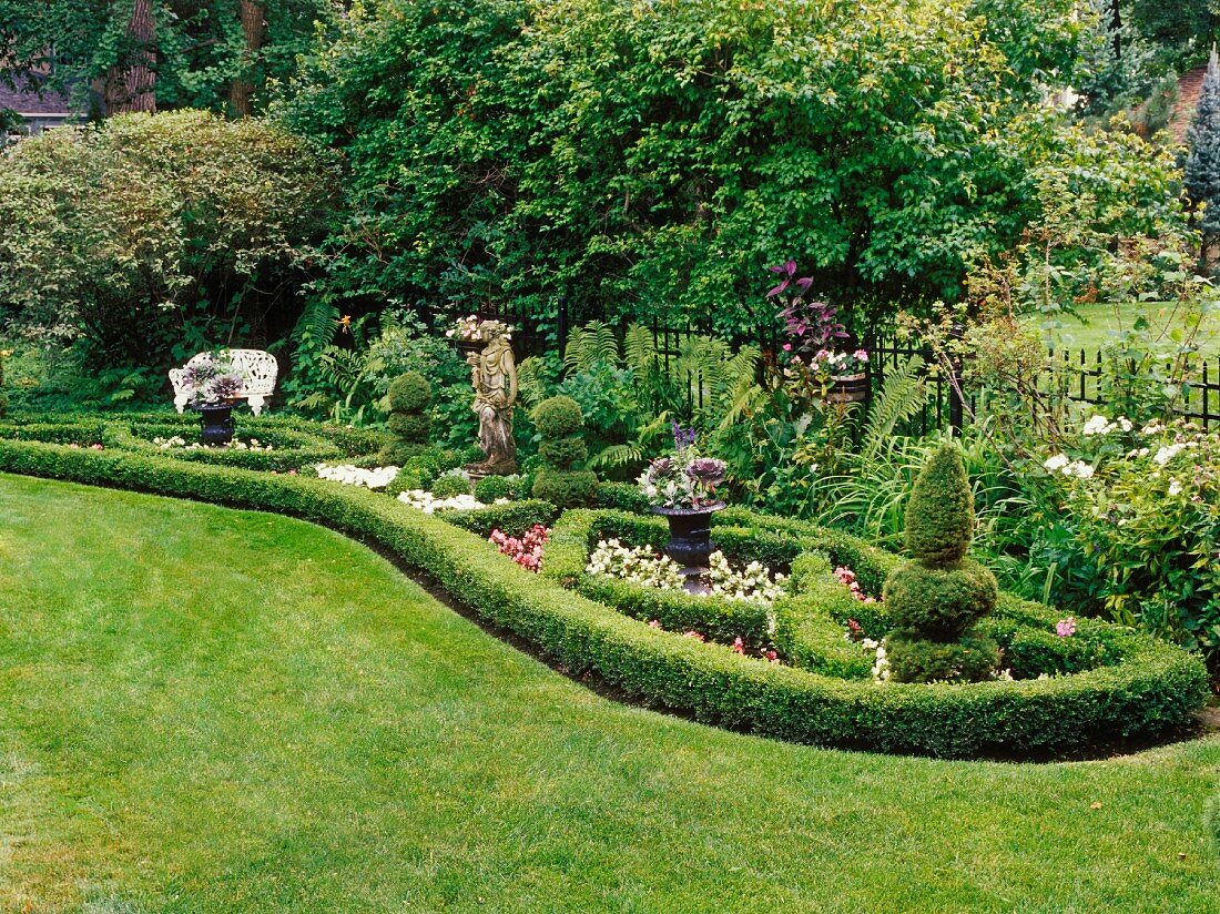 Gepflegte Gartenanlage mit Statue und dekorativem Heckenschnitt