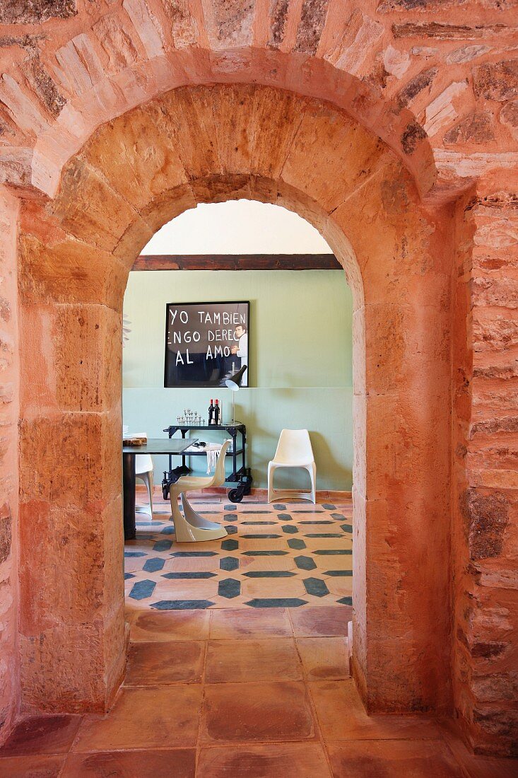 Red brick doorway between kitchen and dining room