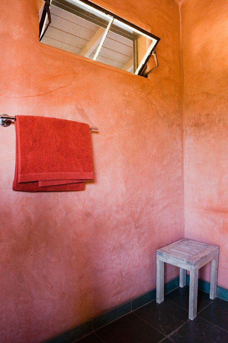 Vintage Bad mit Oberlicht in pastell marmorierter Wand und Holzhocker