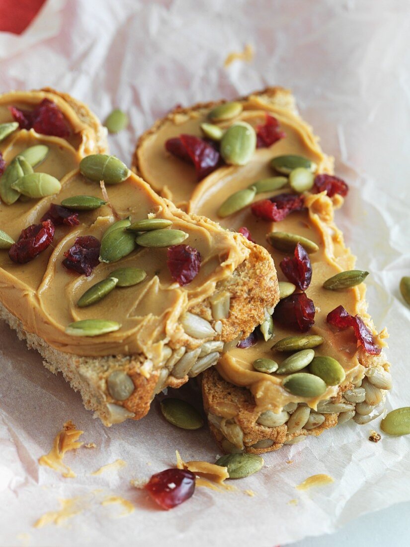 Whole Grain Bread Topped with Peanut Butter, Pumpkin Seeds and Dried Cranberries