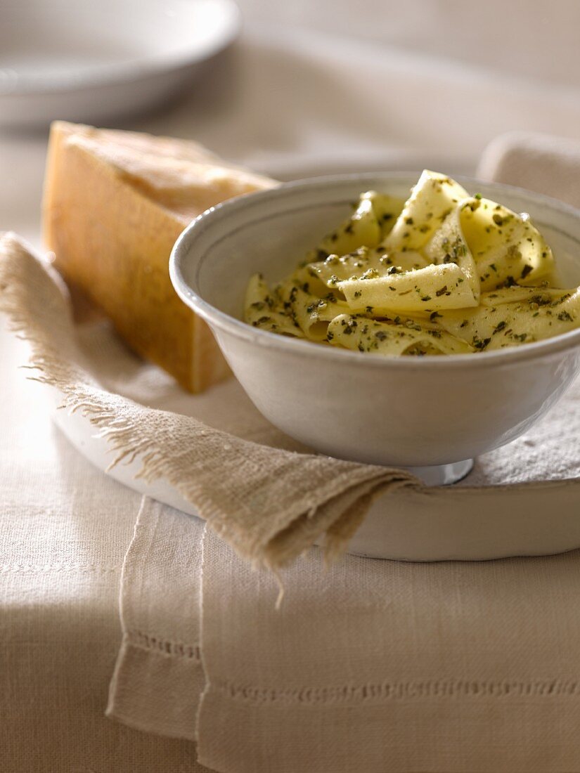 Pasta Tossed with Pesto; Wedge of Parmesan Cheese