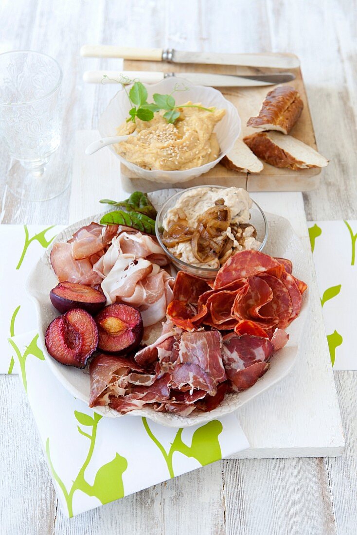 A meat platter with onion spread and hummus for Christmas dinner