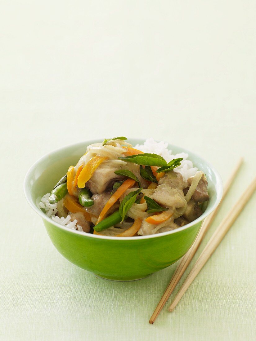 Chicken Stir Fry Over Rice in a Green Bowl; Chopsticks