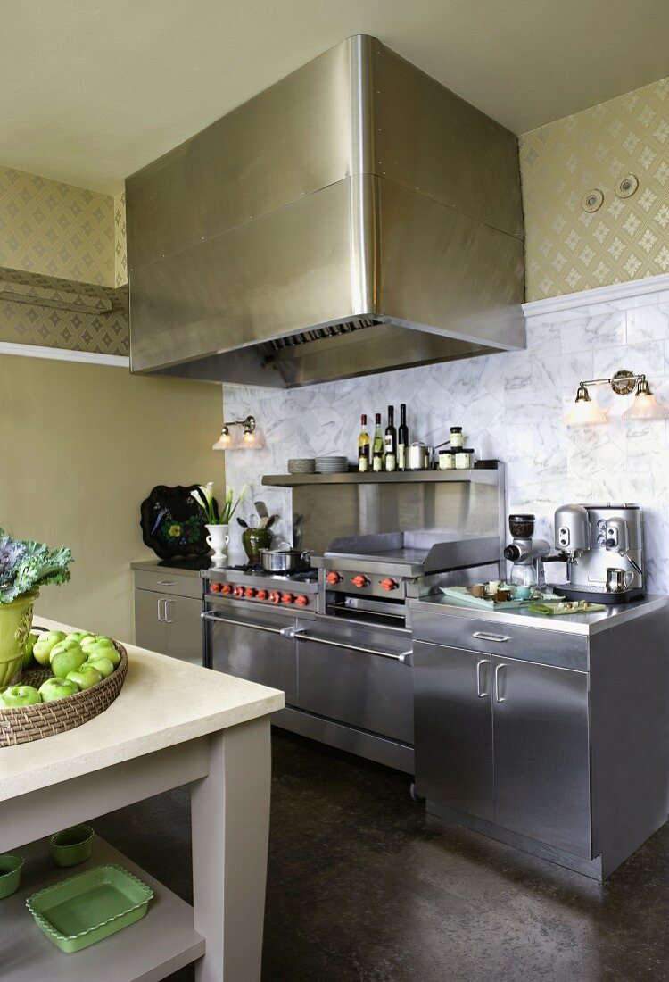 Stainless steel kitchen counter with extractor hood and simple kitchen table