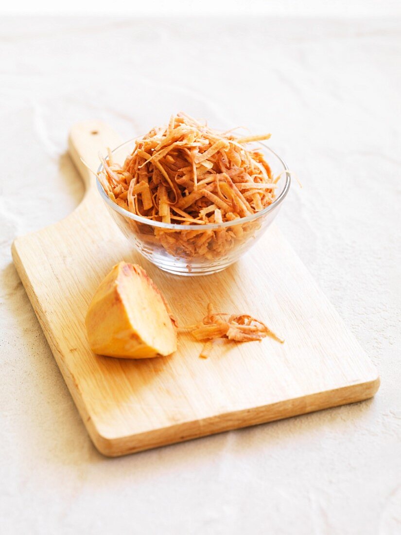 Grated sweet potatoes in a glass bowl