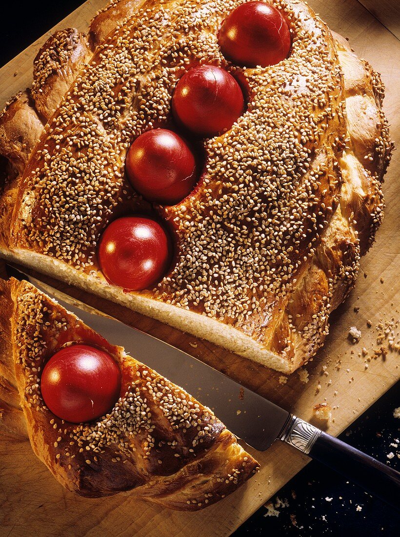 Easter bread with red eggs baked in, sprinkled with sesame
