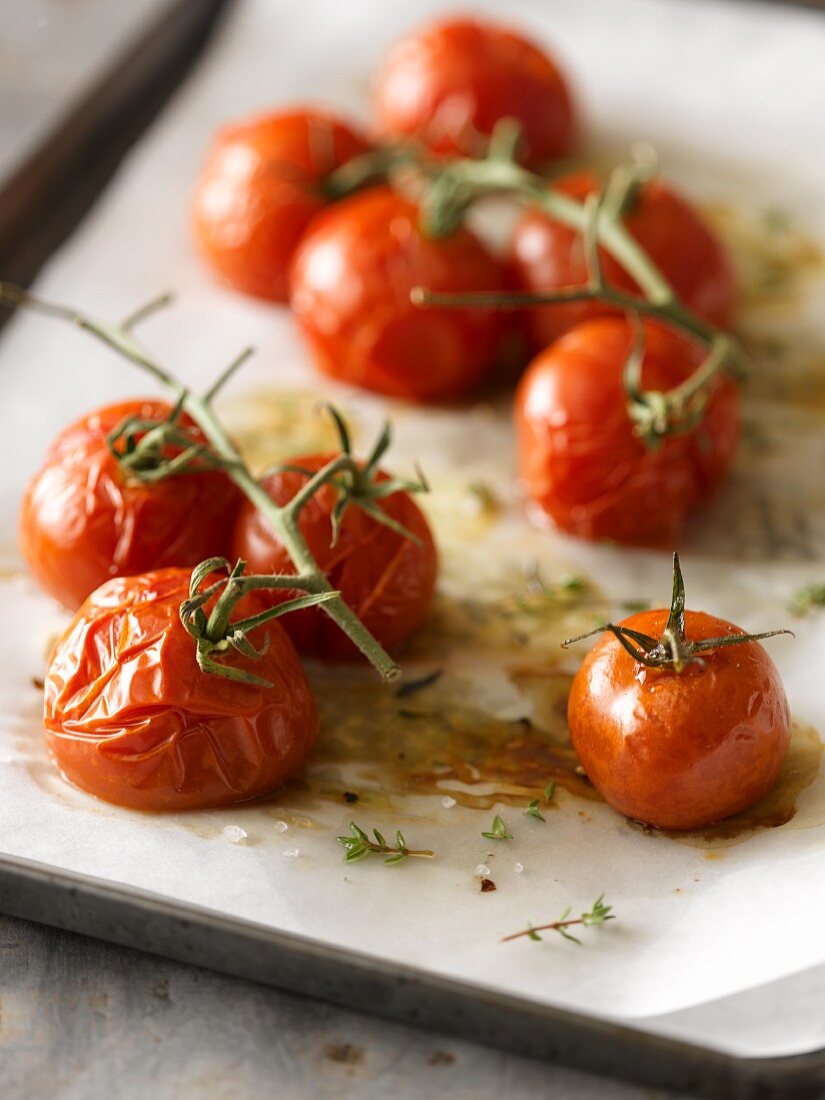 Roasted Cherry Tomatoes on the Vine; Drizzled with Olive Oil, Sea Salt and Thyme Sprigs; On Parchment Lined Baked Sheet